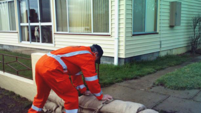 SES worker sandbags a house at Campbell Town against risng flood waters.