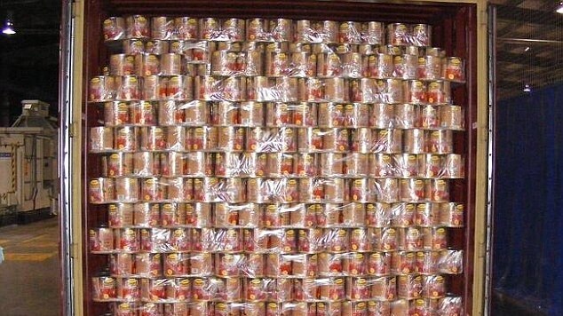 A shipment of tomato tins in a shipping container.