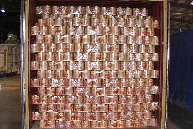 A shipment of tomato tins in a shipping container.