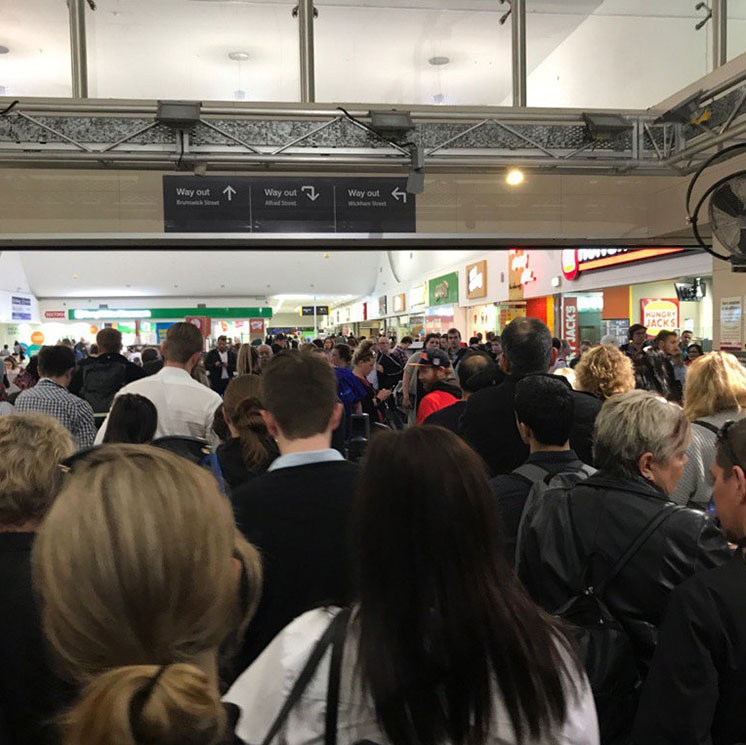 Hundreds of commuters leave a station in Brisbane's CBD as trains come to a standstill during peak hour on June 28, 2017.