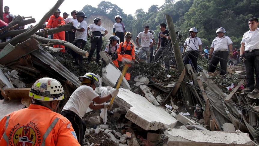 Rescue team members search for mudslide victims in Santa Catarina Pinula, on the outskirts of Guatemala City