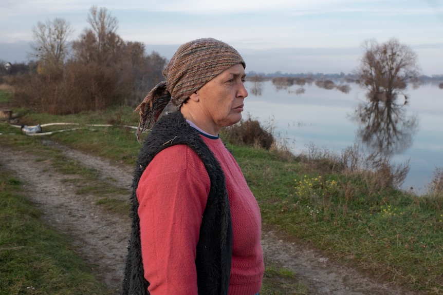 Tetyana Samoilenko walks near the flooded area of her village.