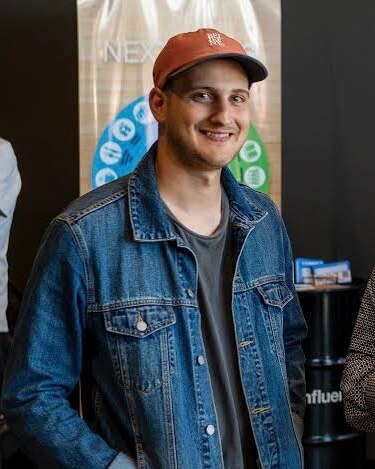A man wearing a red cap smiling at the camera