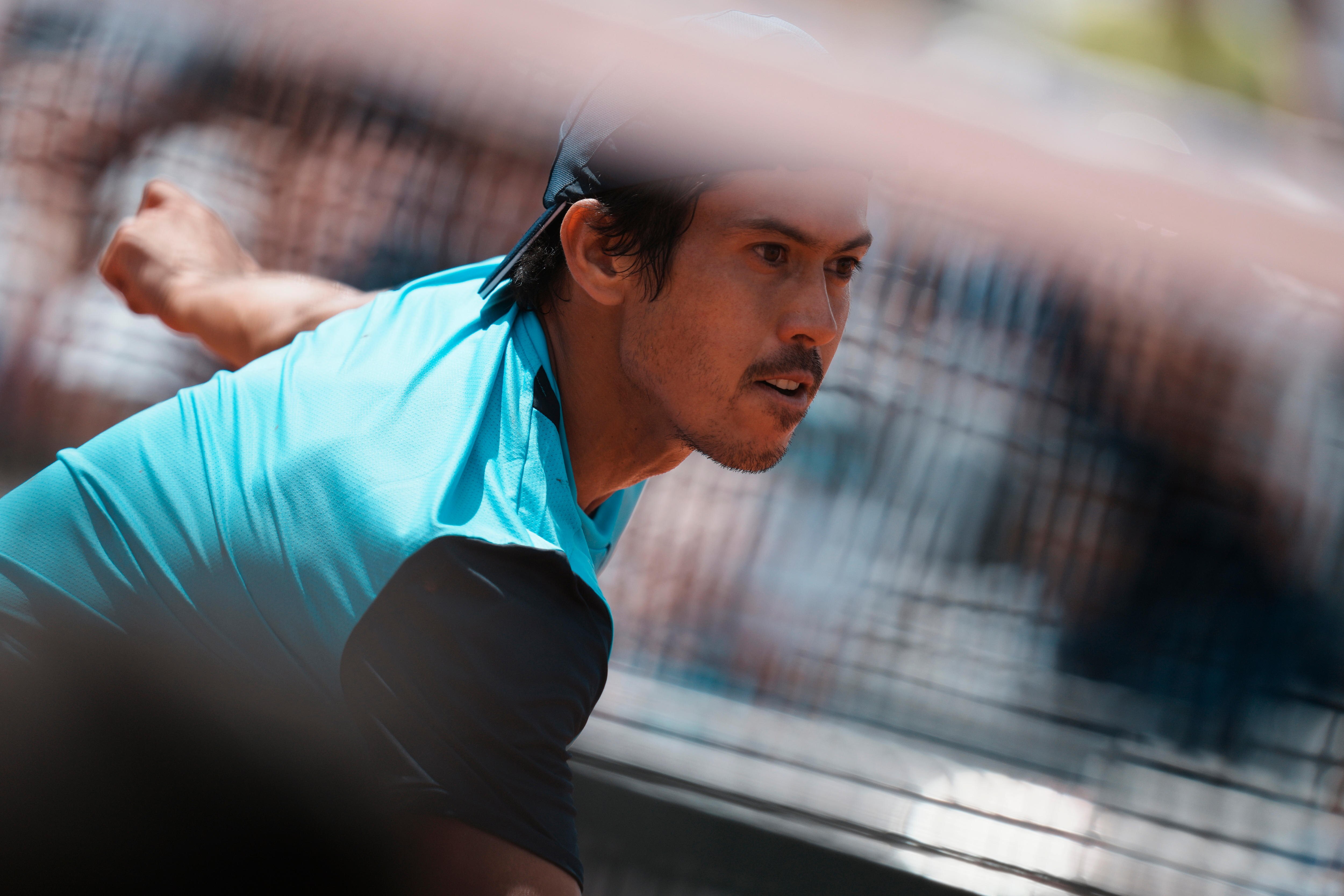 Slightly obscured by the net blurred in the foreground of the image, Kubler looks focused on the court