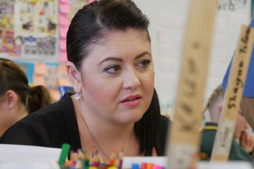 A close up photo of a woman in a primary school classroom.