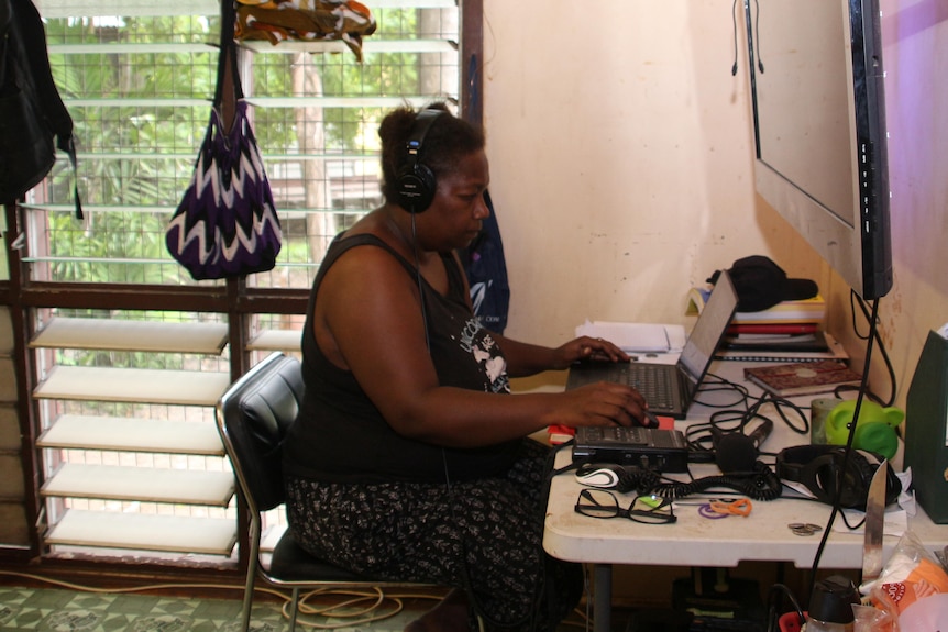 Belinda working at a desk in front of a laptop.