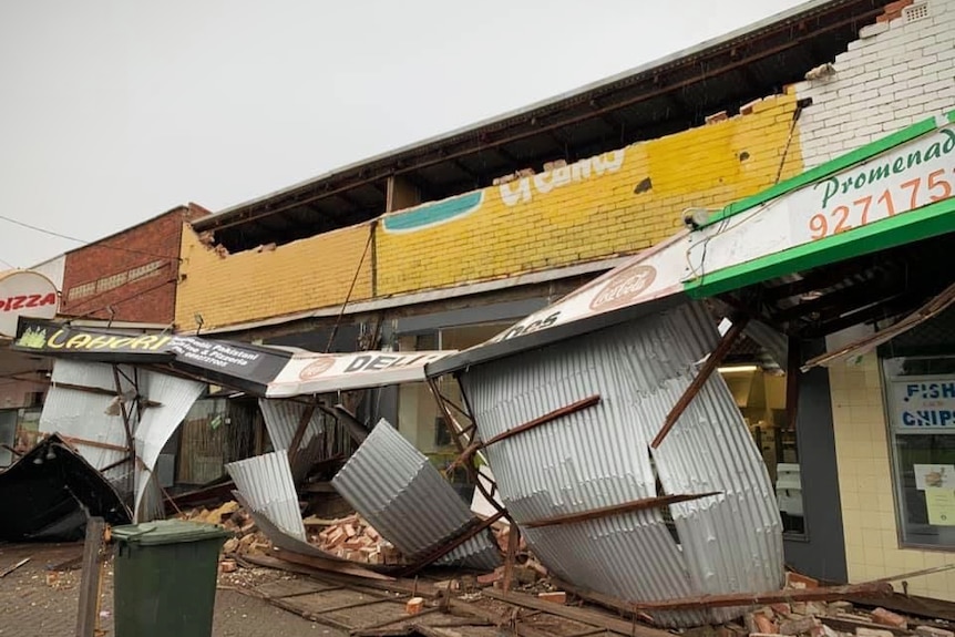 A row of shops with the front facade missing from storm damage