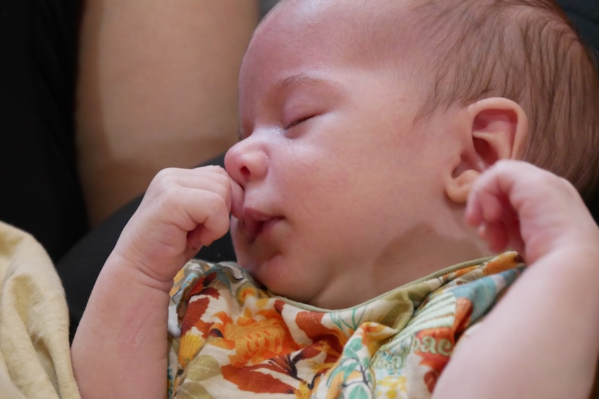 Baby sleeping with hand near mouth