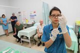 A health clinic staff member prepares vaccinations for Chief Minister Michael Gunner and Chief Health Officer Dr Hugh Heggie