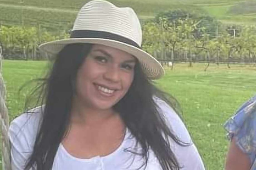 image of young woman with black hair in whit hat at a winery