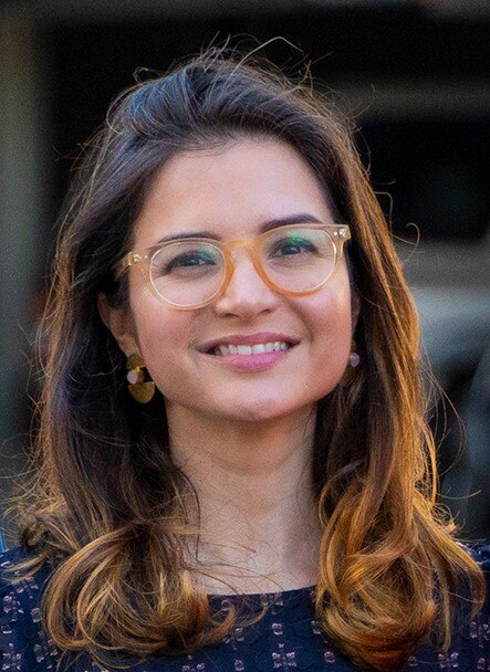 Kate Gould smiles, standing outdoors.