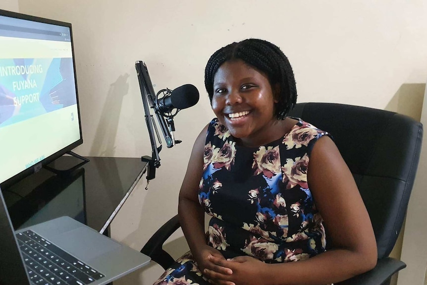 Sizol Fuyana sitting at her desk smiling at the camera