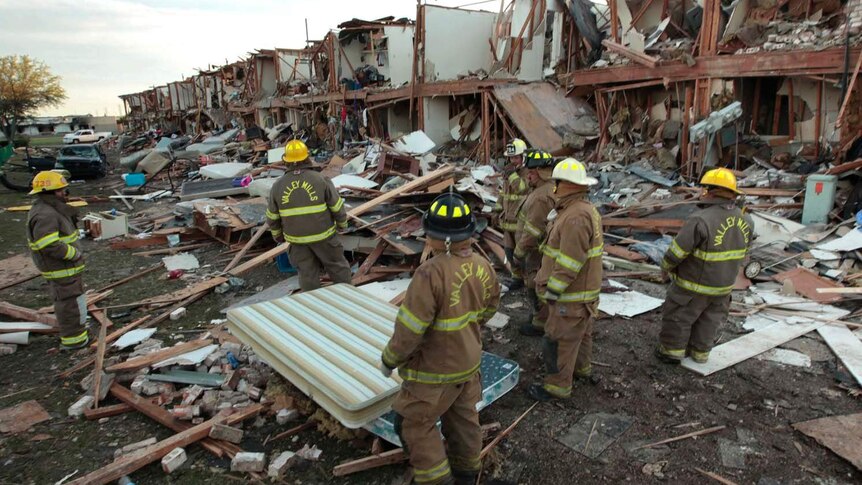 Firefighters work at the devastated ruins of an apartment building in West, Texas