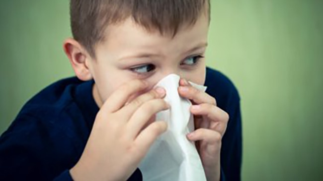 Boy blowing nose.