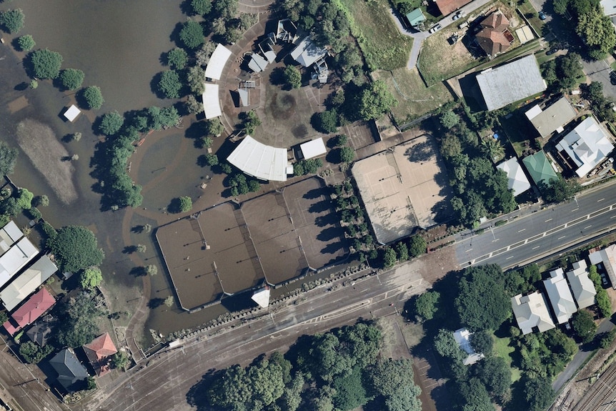Three flooded tennis courts and two courts showing evidence of flooding are seen from above.