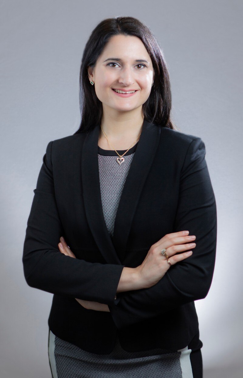 A woman in a black jacket smiling