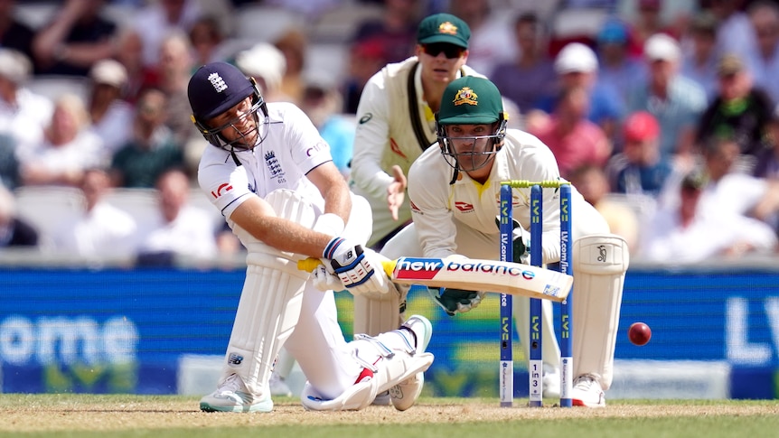 Joe Root plays a sweep shot as Alex Carey watches on from behind the stumps