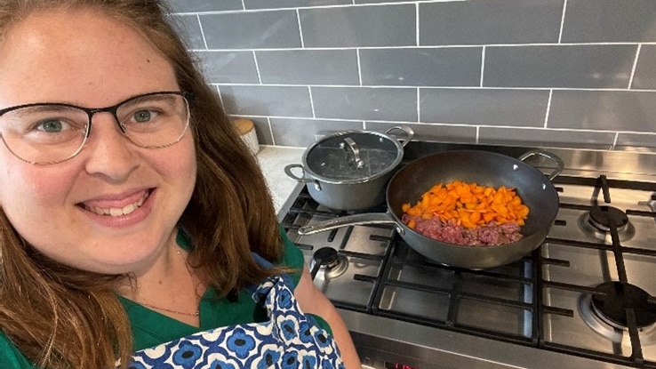 Rachael Hallett in front of a stove looking happy