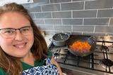 Rachael Hallett in front of a stove looking happy
