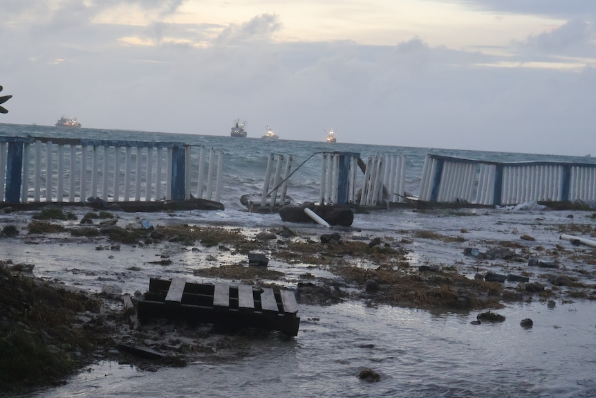 The sea level appears high on the coast, with ships in the background, during a king tide at Funafuti, Tuvalu. 