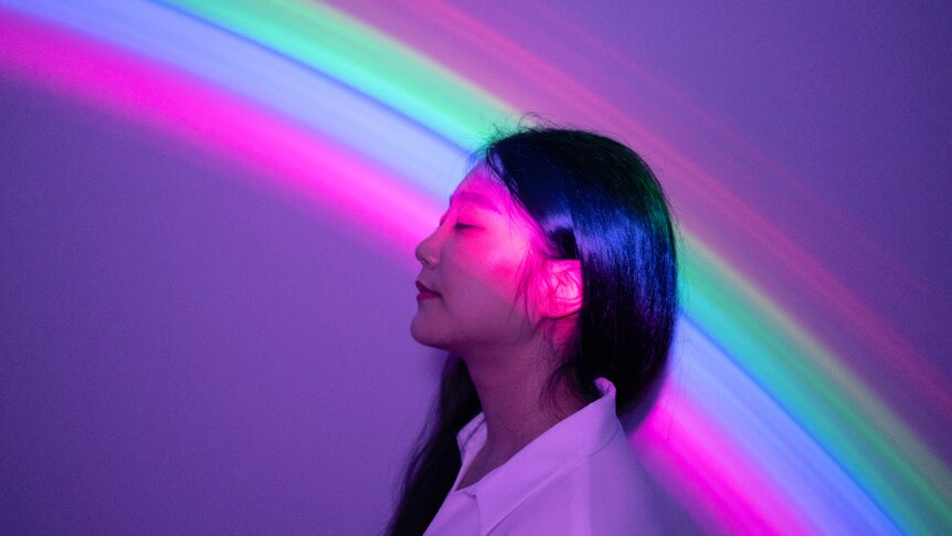 A young Asian woman on rainbow background