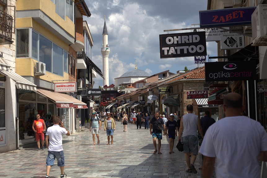 A shopping strip with a sign overhead saying OHRID TATTOO