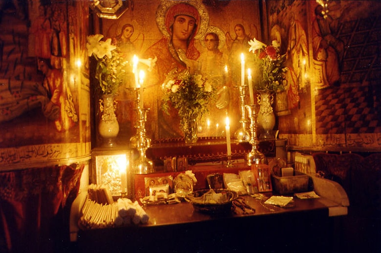 Ein Foto von einem kerzenbeleuchteten koptischen Altar.