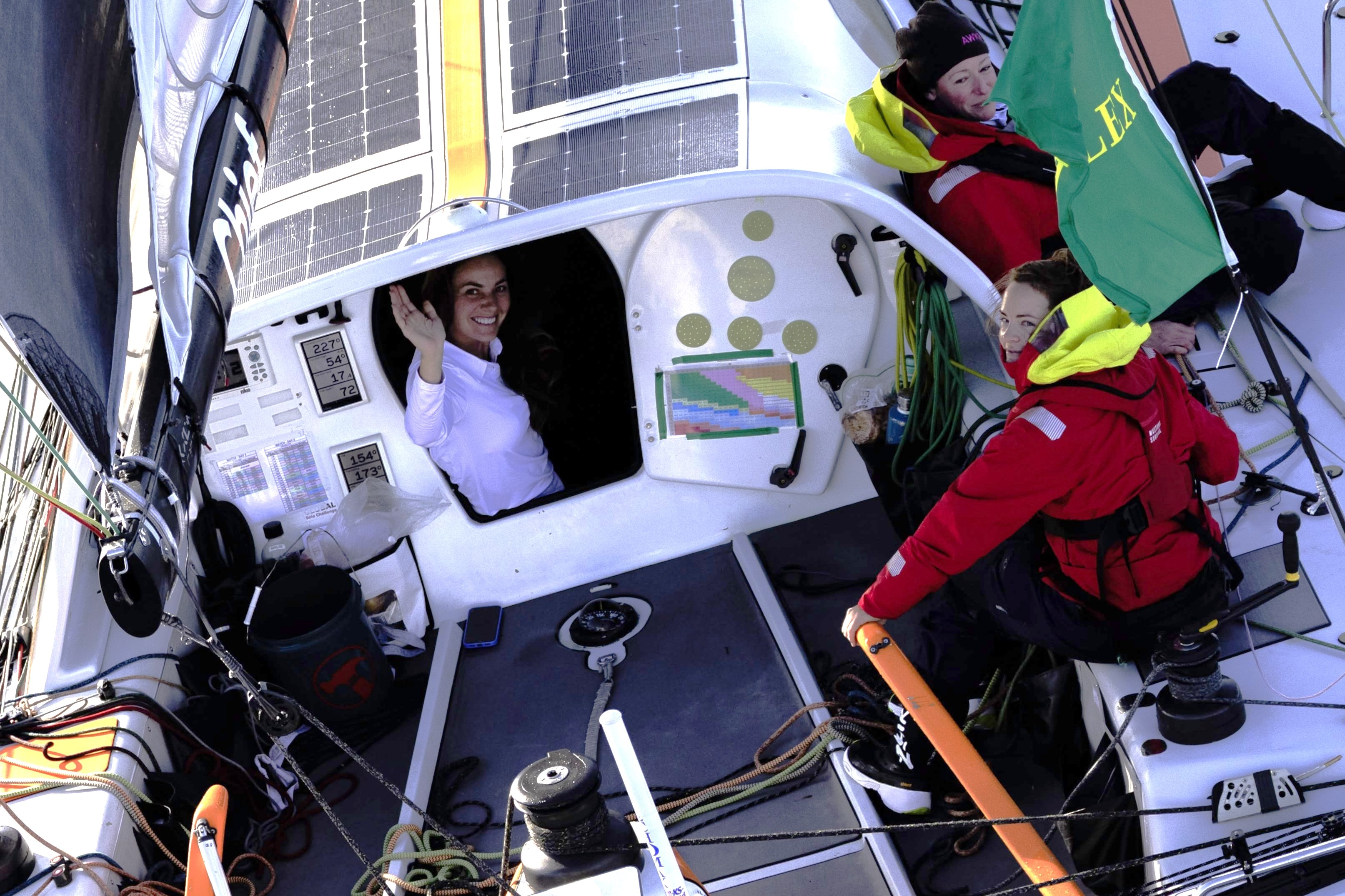 Un miembro de la tripulación saluda desde un yate en el mar.