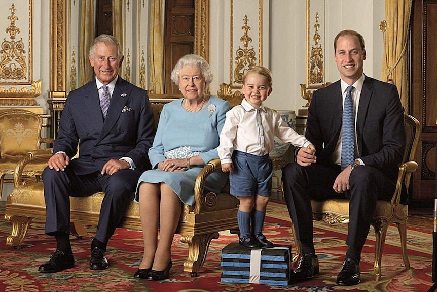 Prince Charles, Queen Elizabeth II, and Prince William seated, with Prince George standing on a small raised platform.