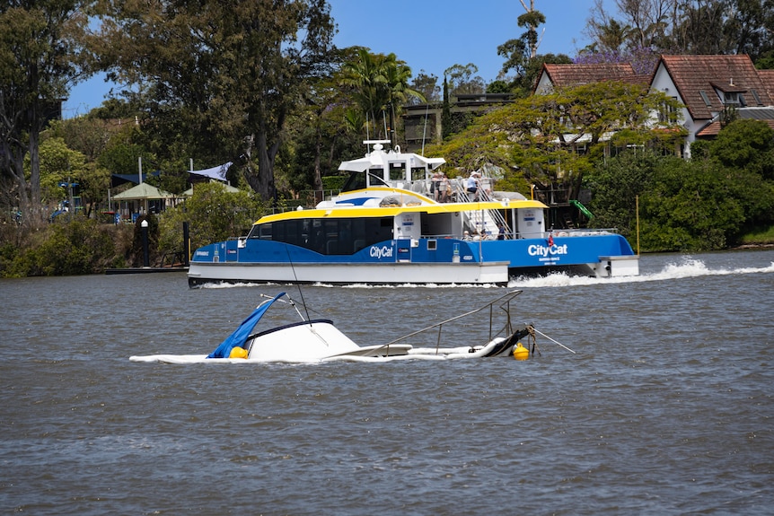 A ferry next to a sunken boat