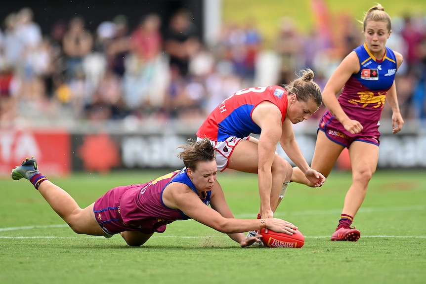 Dakota Davidson launches for the ball against Maddi Gay of the Demons