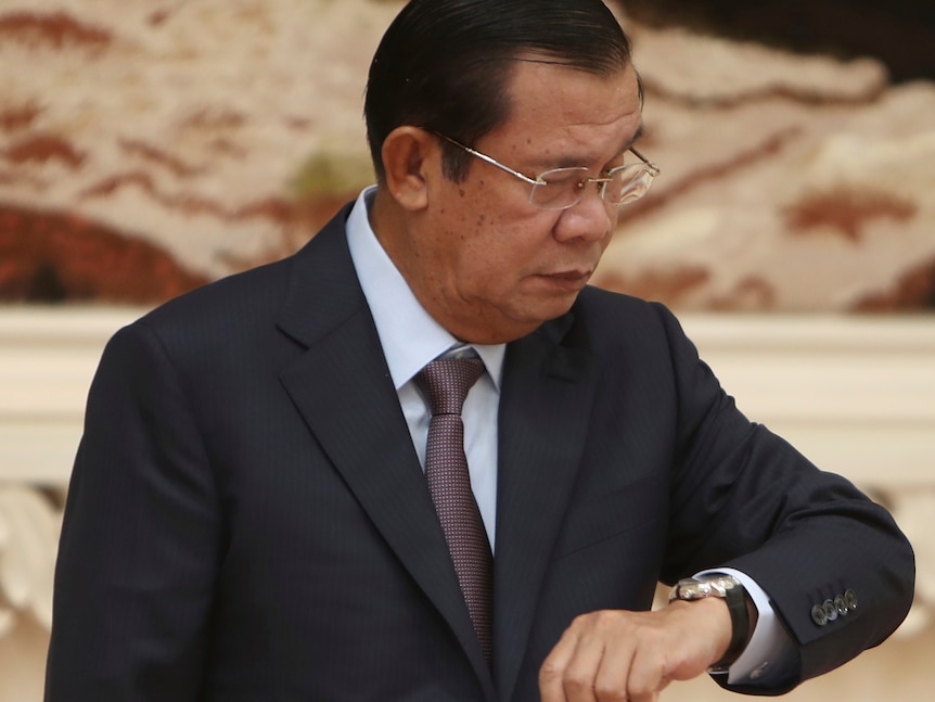 An archive image shows Hun Sen looking down at his wrist watch