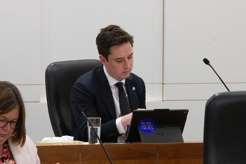 A man reads notes inside the ACT's Parliament.