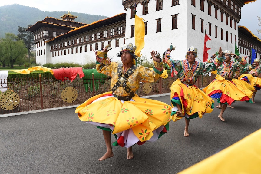 A procession of dancers in yellow.
