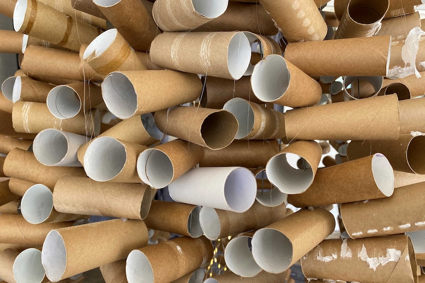 A close up photo of stacks of toilet paper rolls