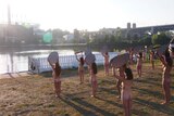 Women stand naked holding mirrors across from the site of the RNC in Cleveland.
