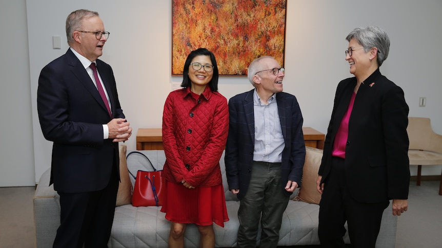 Sean Turnell and his wife Ha Vu standing and smiling with Prime Minister Anthony Albanese and Foreign Minister Penny Wong