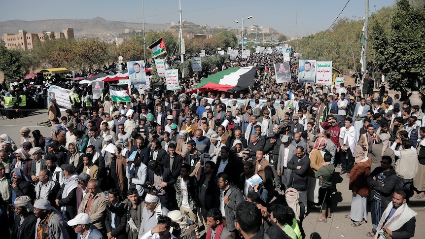 large crowd of protesters holding signs in Yemen