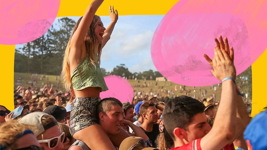 A young woman cheers from a mans shoulders in the crowd at Byron's falls festival.