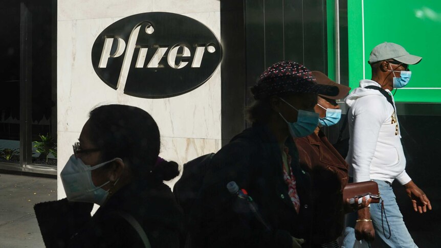 Pedestrians walk past Pfizer world headquarters in New York