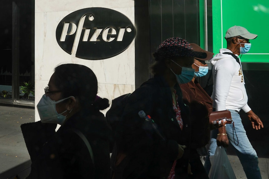 Pedestrians walk past Pfizer world headquarters in New York