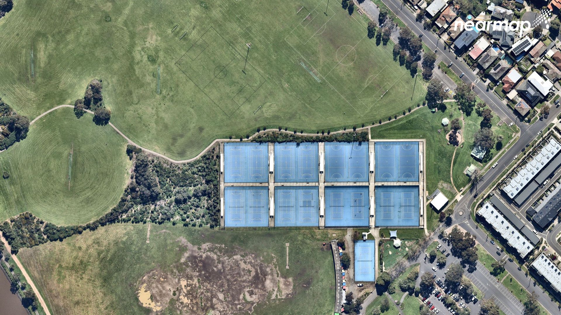 A picture from above shows sporting fields and tennis courts, surrounded by houses