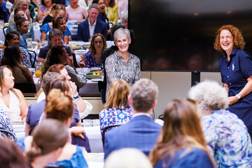 Judy Murray sits on a stool in front of a room of people