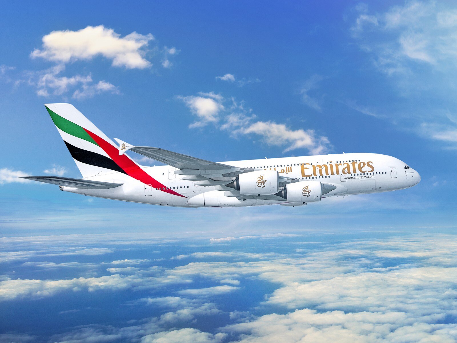 emirates airplane in the sky with clouds in theh background