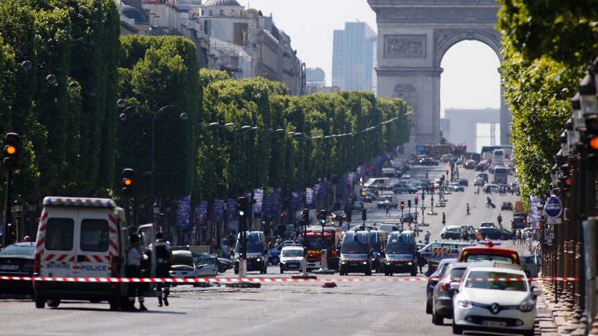 A wide shot shows police and emergency services on the Champs Elysees.