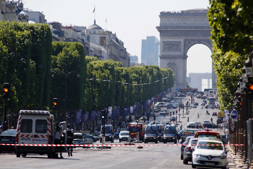 A wide shot shows police and emergency services on the Champs Elysees.