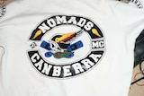 The back of a jumper with the logo Nomads Canberra on it