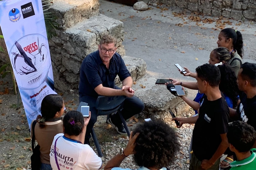 A man being interviewed by several journalists