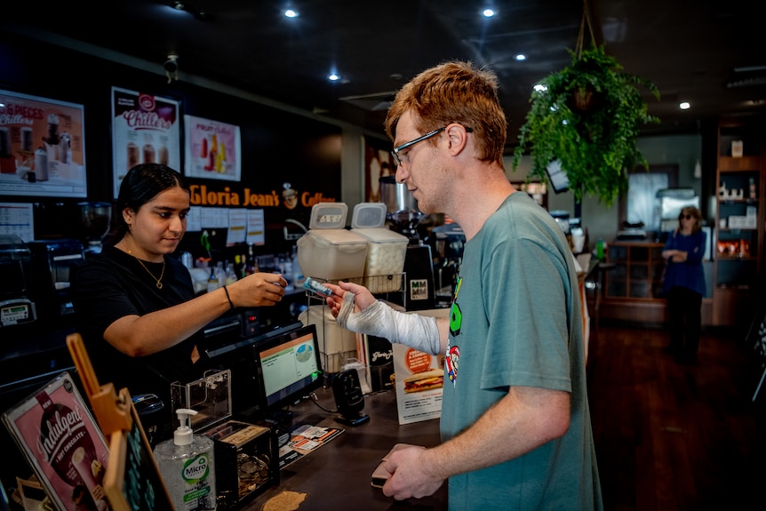 A young man buying a coffee.