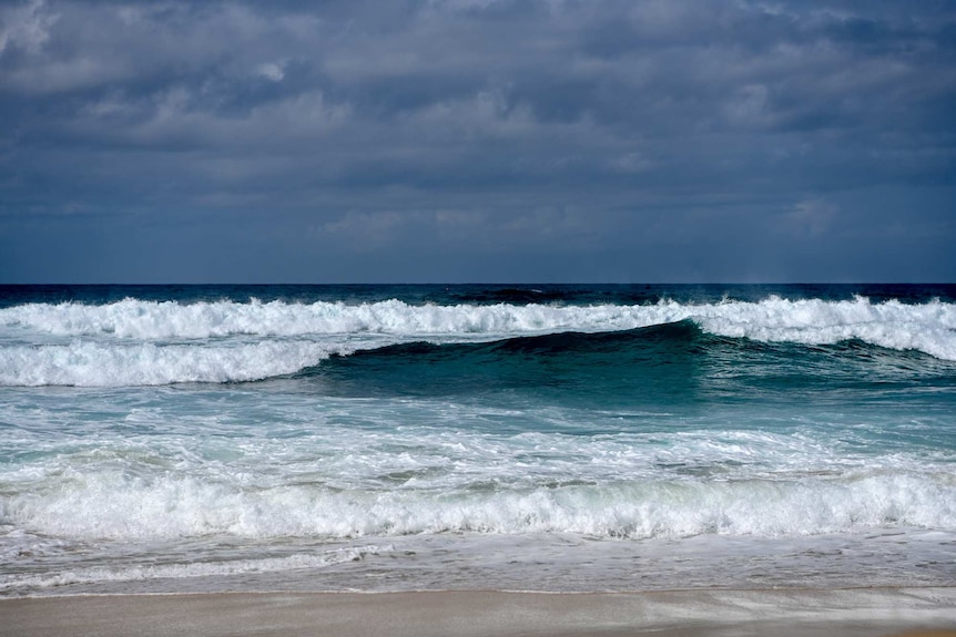 A shot of a wave crashing on a beach.